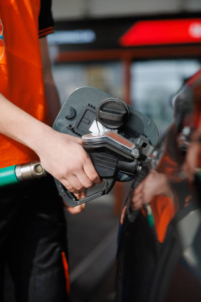 istock Hand holding gas nozzle in tank and refueling 2148963171