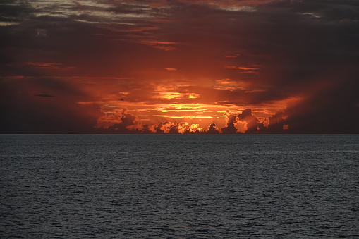 Amazing display of firey clouds during sunset over the ocean