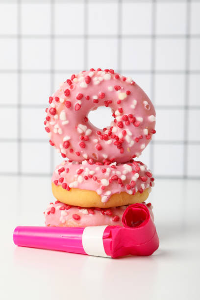 Traditional Berliner for carnival and party. German Krapfen or donuts with streamers and confetti. Colorful carnival or birthday image
