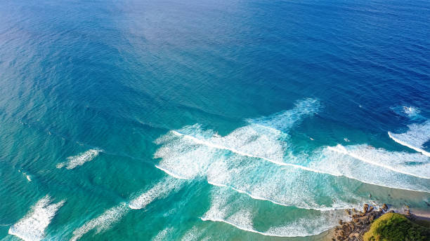 istock Patterned foamy ocean waves roll in and approach sandy beach. Majesty turquoise sea. Top view drone. 2148965361