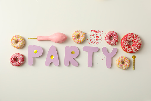 Donuts, balloons and word party on white background