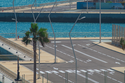 Road markings, directional arrows, divided lanes of carriageway, road going to marina, harbor.