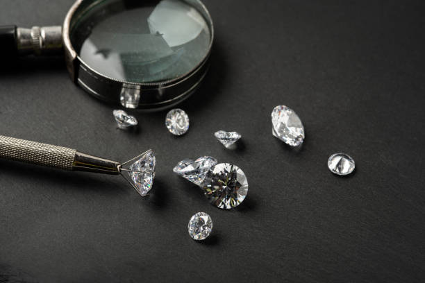 istock Brilliant cut diamond held by tweezers on black background 2148965773