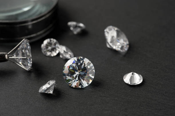 istock Brilliant cut diamond held by tweezers on black background 2148965803