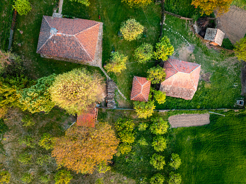 Idyllic aerial view of a country house with a yard, ancillary buildings and an orchard