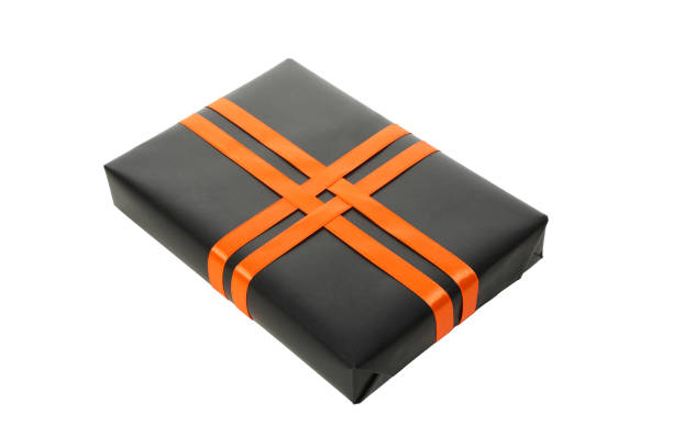 horizontal photograph of a group of wrapped presents, boxes, bags, and gifts, decorated with orange and white bows and ribbons