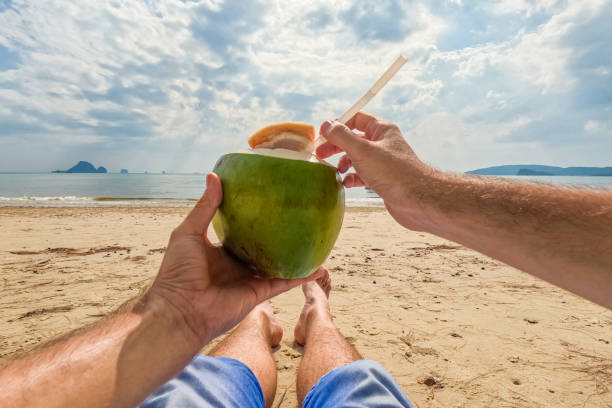 istock Young Man Drinking From A Coconut Shell On The Ao Nang Beach In Thailand 2148968323