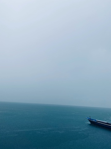 rainy ocean with boat and tree objects