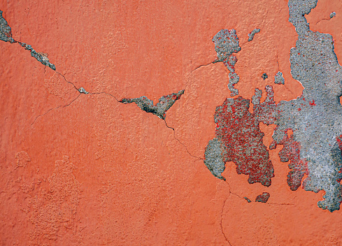 Old weathered orange concrete wall with peeling paint and orange Concrete crack \ntexture for wall background and vintage grunge