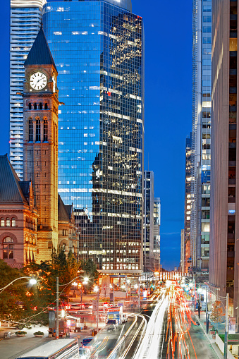 traffic on queen street at night with old city hall and clock tower