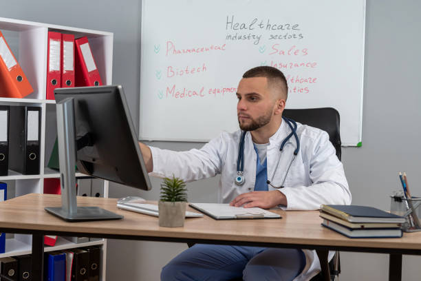 istock doctor man sitting at the desk using laptop computer for webinar training ar medical themes 2148970548
