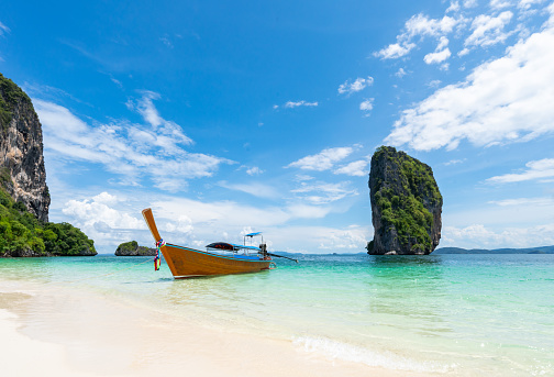 Thai traditional wooden longtail boat and beautiful sand beach in Krabi province. Thailand.