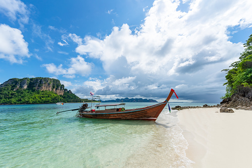 Thai traditional wooden longtail boat and beautiful sand beach in Krabi province. Thailand.