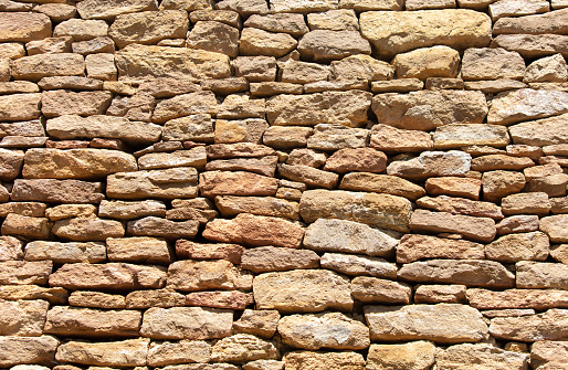 Ancient stone bricks in the wall as a background. Texture.