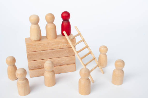 Wooden dolls looking at the top management and leaders. Leadership concept.