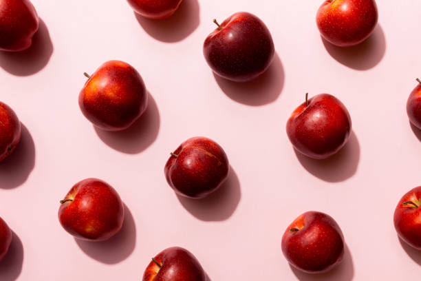 istock Many red apples on colored background, top view. Autumn pattern with fresh apple above view 2148977847