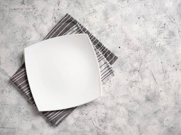 istock A large white empty plate lies on a decorative towel on an abstract background. 2148978342