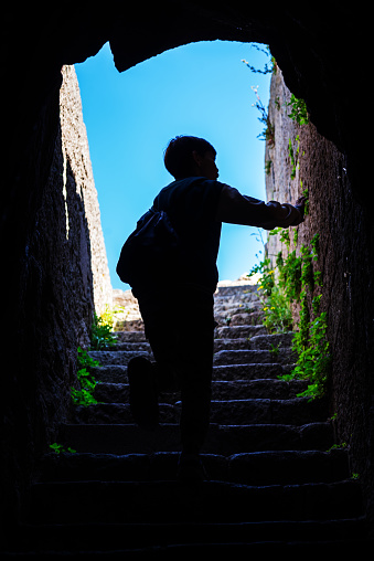 little boy exploring the surroundings by climbing the stairs with his bag on his back