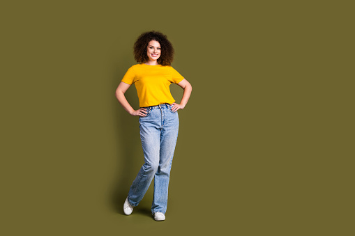 Full body size photo of young charming beautiful wavy hair woman in yellow t shirt and jeans posing isolated on khaki color background.