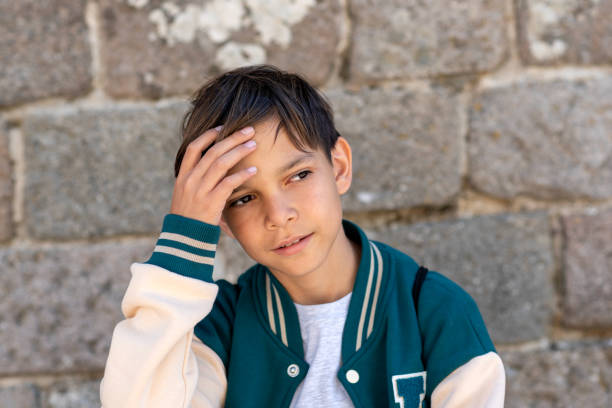 istock Sweet, handsome 11-year-old boy looking around with his hand on his head 2148979648