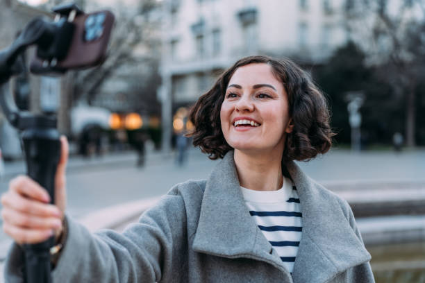 istock Young female content creator using smartphone to record outdoors. 2148979882