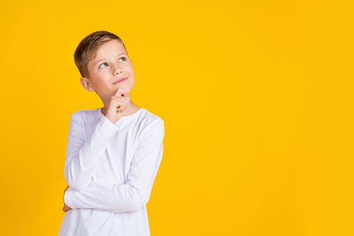 Photo of funky dreamy boy wear white shirt arm chin looking empty space isolated yellow color background.