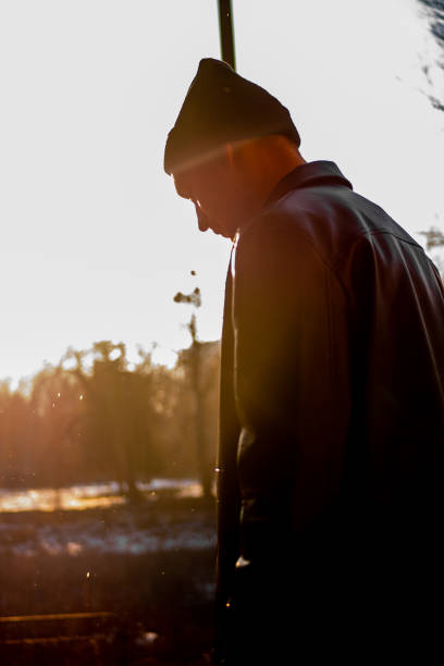 istock A handsome young guy in a black leather jacket and hat poses sideways with his head down 2148981061