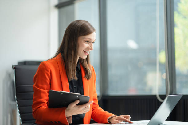 istock Businesswomen hand working with tablet and laptop computer with documents on office desk in modern office 2148981163