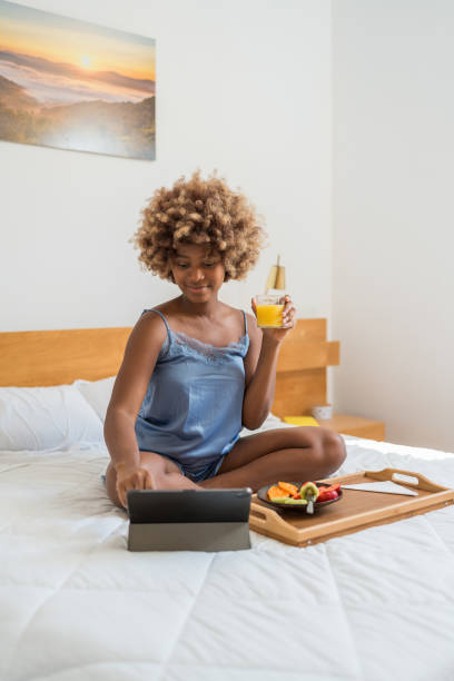 young woman having breakfast in bed - llao llao hotel imagens e fotografias de stock