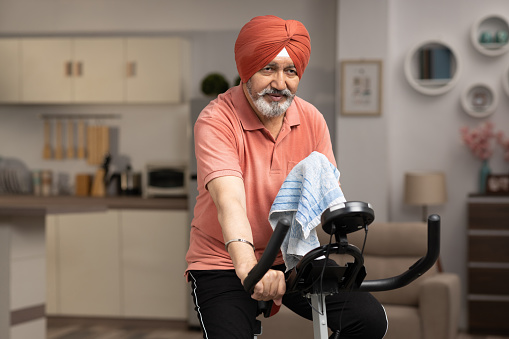 Mature Sikh man exercising at home