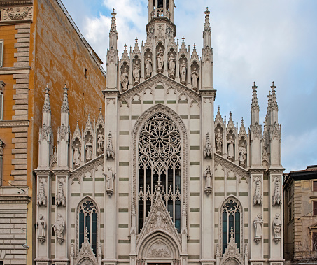 Closeup detail showing ornate exterior facade of old catholic church in rome Italy with statues and spires