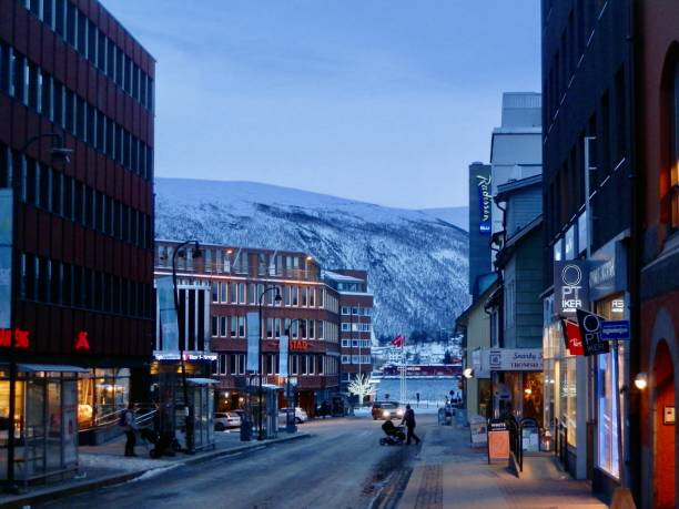 This Tromso street leading to the harbor is illuminated just after 9:00 in the morning in January as the sun prepares to rise.