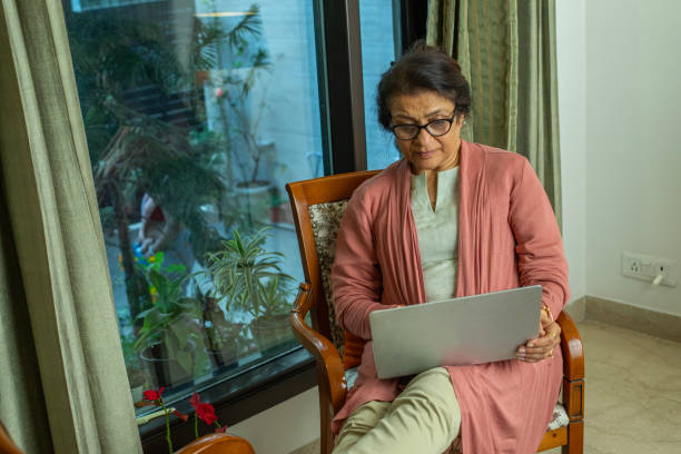 istock Old woman using laptop at home 2148985478