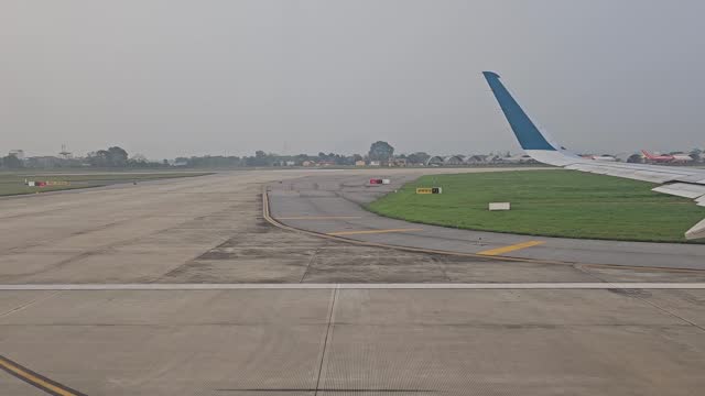Looking through airplane window before taking off. The plane parked on the runway at Noi Bai airport, Vietnam.