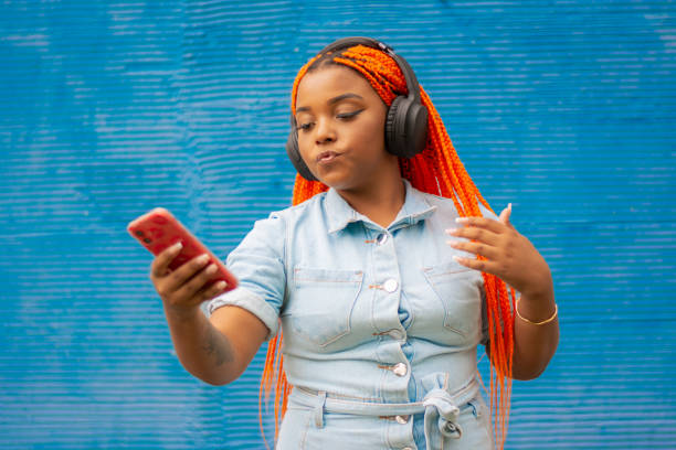 istock Young brunette woman with dreadlocks typing on a smartphone 2148986397