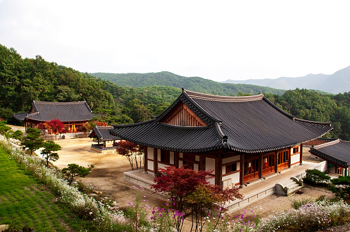 South Gyeongsang Province, South Korea: 11.10.2023. Traditional Korean Temple Architecture. A wooden building with a tiled roof and intricate ornaments adorning its facade stands serenely amidst a tranquil landscape. This Buddhist temple in South Korea exemplifies the harmonious blend of traditional Korean architecture with the natural surroundings.
