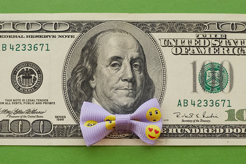 Portrait of Franklin on a 100 dollar bill with a lilac butterfly with smileys, money for fun, money for gifts, funny money, close-up