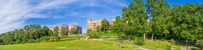 Green Lawn, Landscaped Grass and Trees of Public Park, Residential Co-op Buildings in background and Bright Blue Sky with Clouds, Bay Ridge Neighborhood of Brooklyn, New York.. Canon EOS 6D (full Frame Sensor) Camera and Canon EF 50mm F/1.8 II Prime lens. High resolution stitched HDR panoramic image. 4:1 Image Aspect Ratio. This image was downsized to 50MP. Original image resolution is 69MP or 16622 x 4155px.