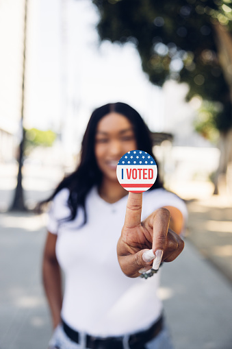 Young woman out of the polling place showing 