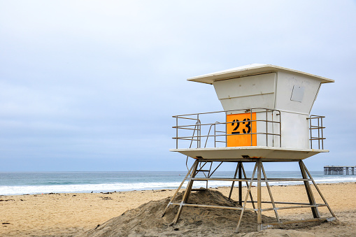 Elevated above sand lifeguard tower at empty Pacific Beach south of historic Crystal Pier in the early gloomy morning, San Diego, California