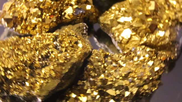 precious shiny large gold nugget found by the prospector spinning on the turntable
