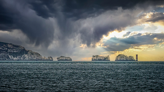 The Needles Lighthouse seen from Milford on Sea , England. Large storm moving in over the ocean, dramatic clouds.