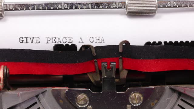 text GIVE PEACE A CHANGE written with old typewriter with black ink