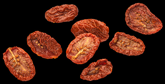 Sun dried tomatoes in olive oil isolated on black background