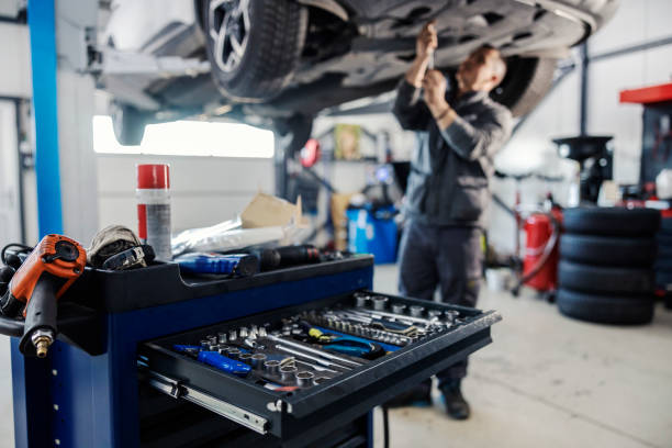 istock Selective focus on mechanic's toolbox with tools in drawer with auto-mechanic fixing car in blurry background at workshop. 2148995704