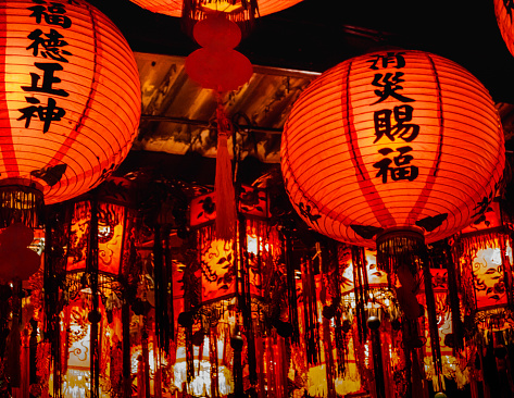 Array of red pendant lanterns and palace lamps are installed on a local temple's ceiling in New Taipei City of Taiwan for birthday celebration of lord of the land. Blessings on lanterns are enriching people's fortune and diminishing possible disaster.