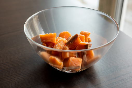 Close-up of raw fresh salmon fillets cut into cubes and presented in a glass bowl