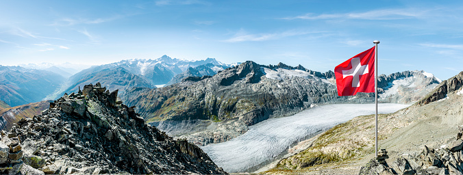Swiss mountain panorama at the Rhone Glacier with Swiss national flag