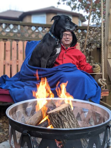 istock A man and his dog sit by a fire on a swing 2149000215