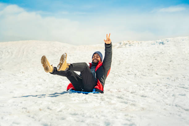 Japanese mid age woman riding a snow sled.